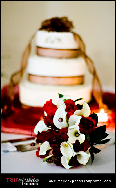 wedding photograph of bride's bouquet in front of wedding cake